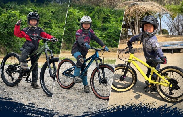 マウンテンバイクにまたがる大野家の三兄弟。それぞれフルフェイスヘルメットとプロテクターを着用し、屋外のダートコースに立っている。